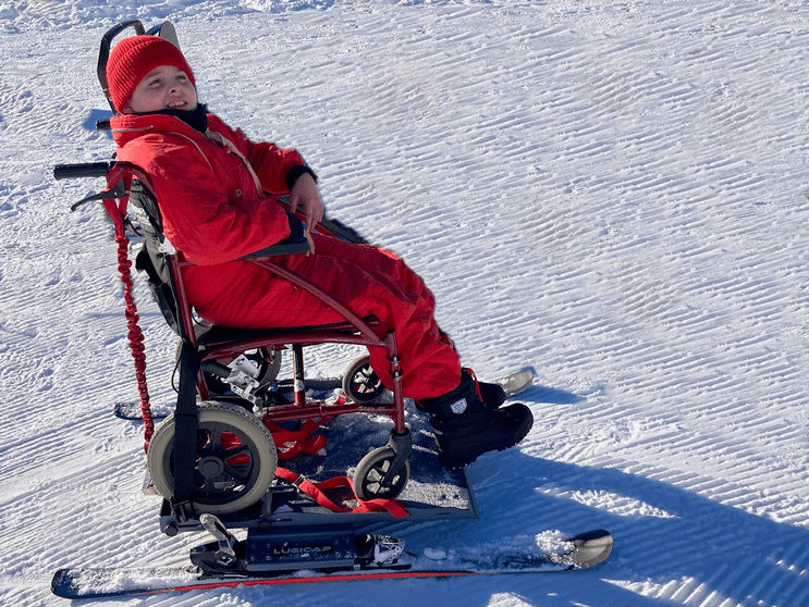 glisse pour enfant lourdement handicapé sur la neige avec son fauteuil roulant